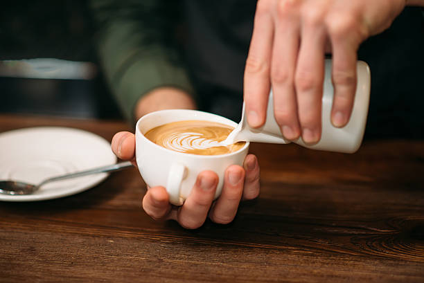 istock Closeup of male hands adding cream to coffee. 632445330