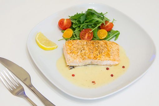 Grilled salmon steak with beurre blanc sauce, selective focus