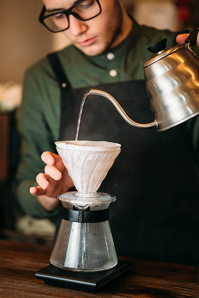 istock Waiter pours hot boiled water in a coffee pot 632445706