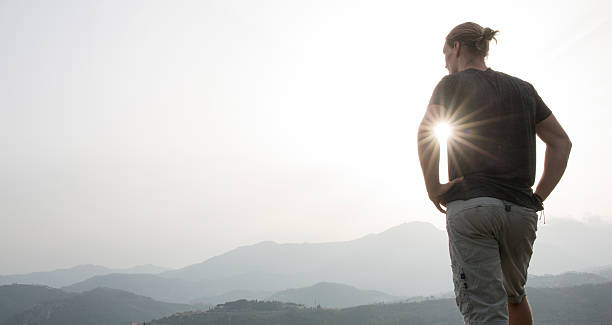 istock Young man looks off to distant hills, sunrise 633863019