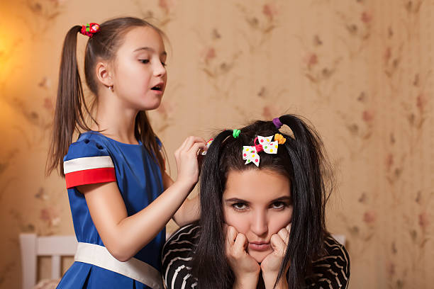 istock Little kid making hairstyle to her mother. 634573450