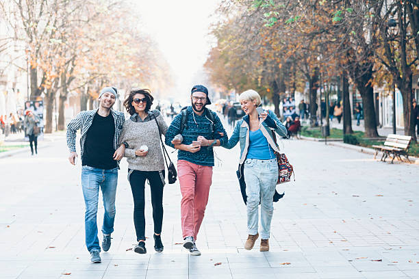istock Friends holding hands and walking in park 634574150