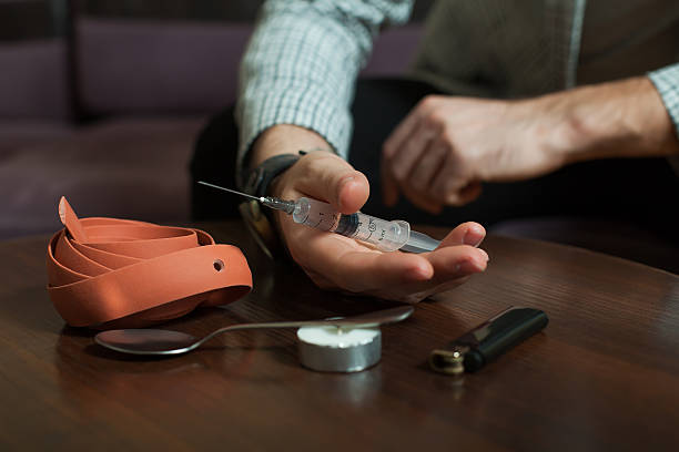 istock Addict preparing a dose of heroin for injection. 634575212