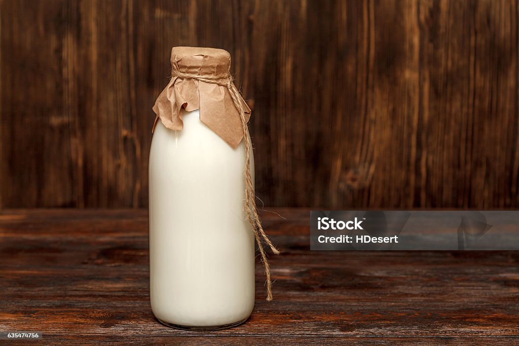 Bottle of milk on rustic wooden table Bottle of milk on rustic wooden table with copyspace Milk Bottle Stock Photo