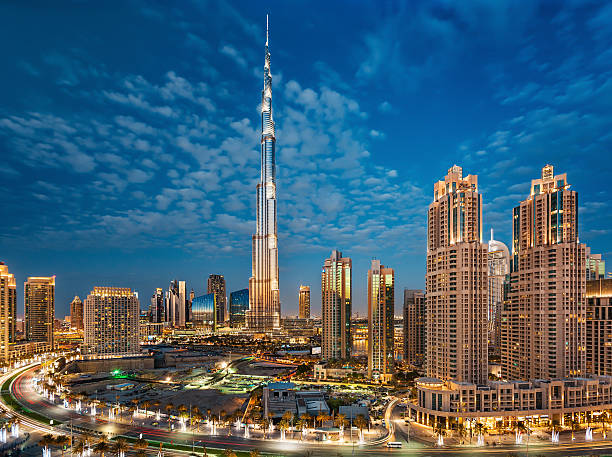 burj khalifa mit dubai downtown towers bei sonnenuntergang - dubai stock-fotos und bilder