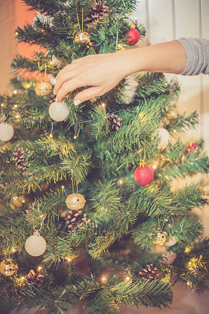 istock Regional Christmas at home - Woman decorating Xmas tree 635478476