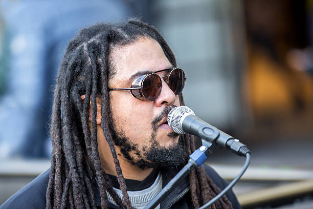 istock Cool singer with dreadlocks in front of mike 635672376
