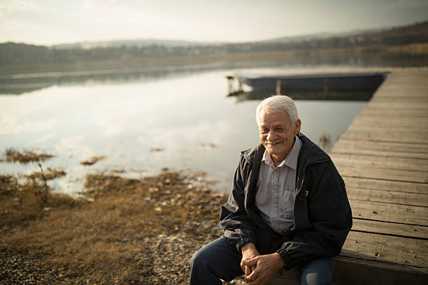 istock Senior man on lake pier 635673036