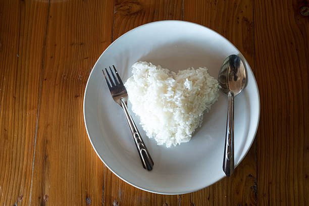istock Rice heart shape on a wooden table in a restaurant. 635673432