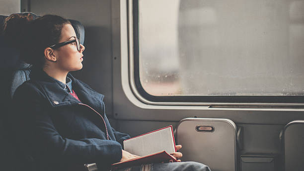 istock Young woman reading on a train 635673444