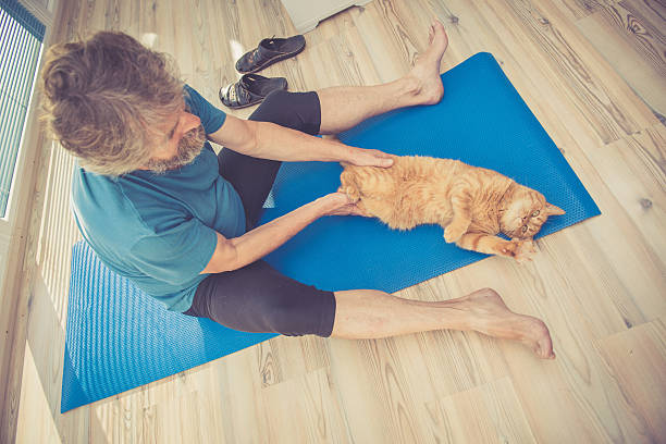 istock Senior Man exercising at Home with his Ginger Cat 635674520