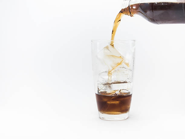 istock cola pouring from plastic bottle in glass filled with ice 635675820
