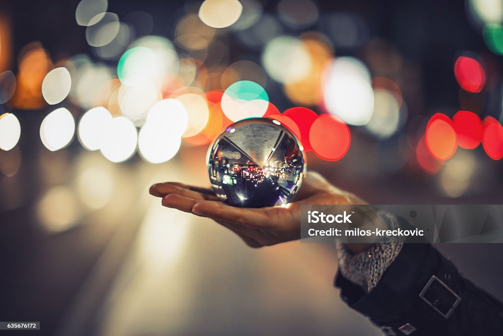 Girl holding crystal ball Girl in city holding crystal ball with beautiful bokeh Crystal Ball Stock Photo