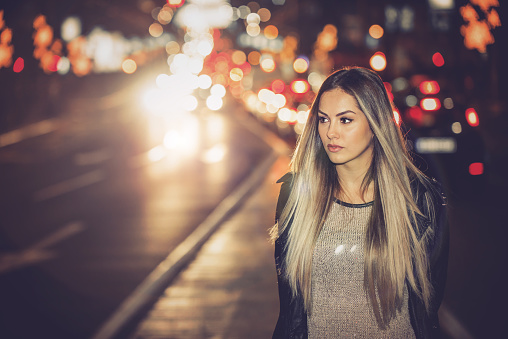 Girl walking between lanes in city during night
