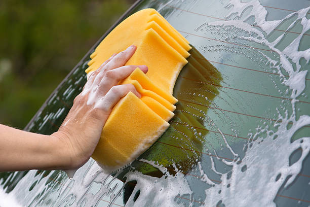 istock hand washing the rear window of a car 635680962