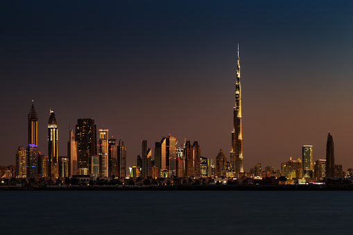 Dubai, UAE - November 27, 2014: A skyline view of Dubai at Sunset from Jumeirah Beach. It showcases the buildings of Sheikh Zayed Road and Burj Khalifa