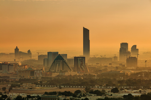 Dubai, UAE - November 28, 2015: The hazy Dubai skyline over the Wafi Pyramids just after dawn in Dubai, UAE