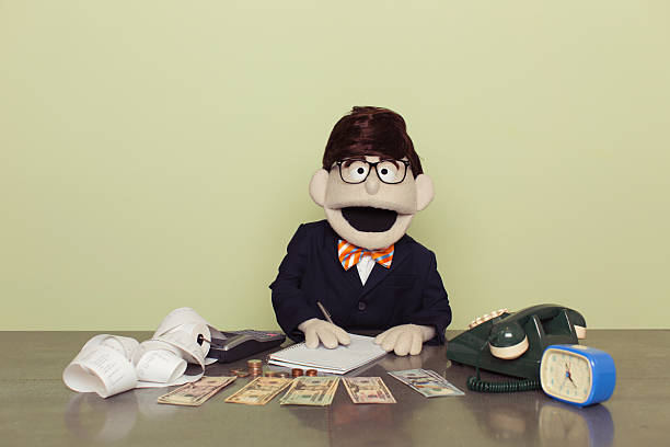 puppet accountant zählt amerikanische dollars mit rechner - puppeteer stock-fotos und bilder