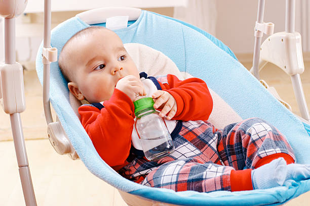 istock Baby boy drinking water from bottle 635697354
