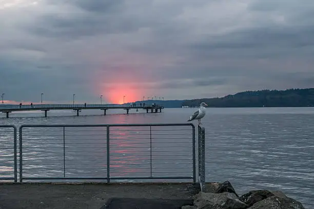 A section of the horizon flares up in red as the sun sets behind the clouds in Des Moines, Washington.