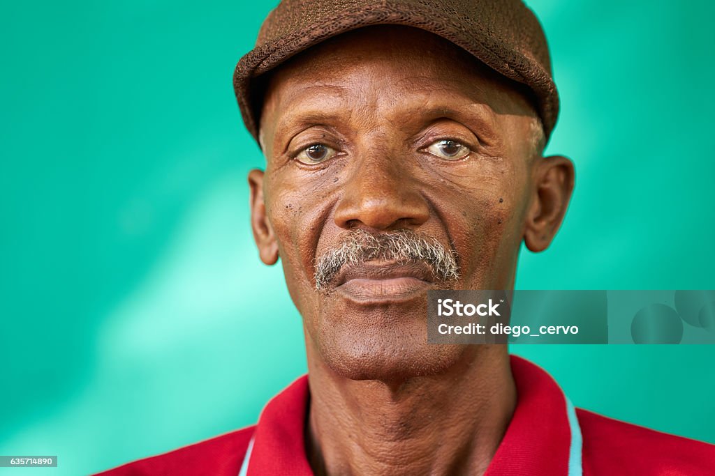 Seniors People Portrait Sad Old Black Man With Hat Real Cuban people and feelings, portrait of sad senior african american man looking at camera. Worried old latino grandfather with mustache and hat from Havana, Cuba African Ethnicity Stock Photo