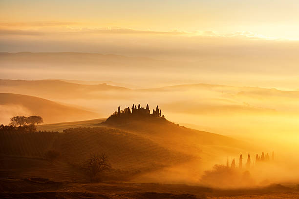 sonnenaufgang mit strahlen über den nebeltälern in der toskana, italien. - chianti region stock-fotos und bilder