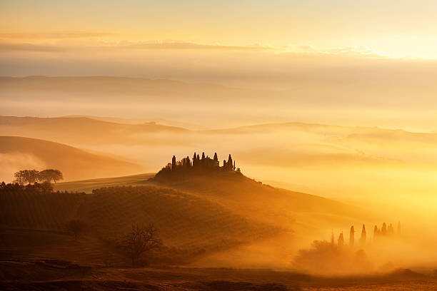 Sunrise with rays over the Misty valleys in Tuscany,Italy. stock photo