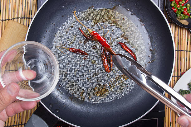 Chef putting fried red dried chlli in the cup