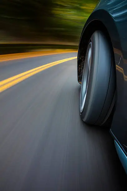 A sportscar making a turn on a country road.