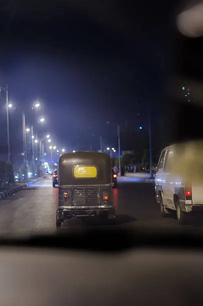 Photo of Tuktuk in the middle of traffic (developing country)