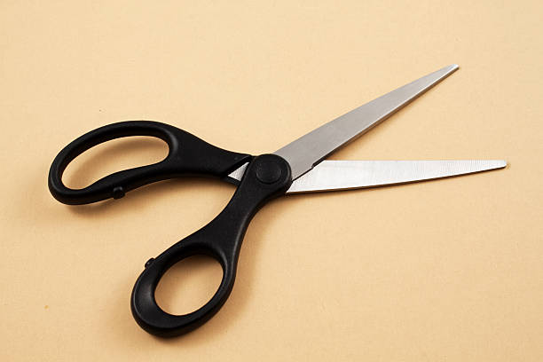istock Black Handled Scissors On A Yellow Background 635723134
