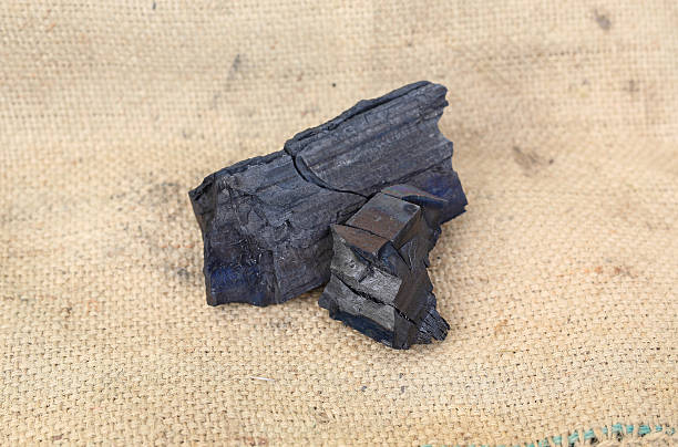 istock Natural wood charcoal on sack background, 635725894
