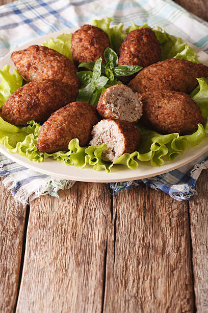 istock Hot kibbeh meatballs with bulgur and pine nuts closeup. Vertical 635732784
