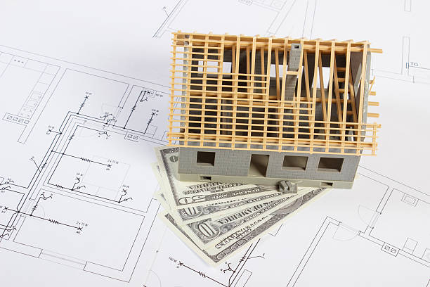 istock House under construction and currencies dollar on electrical drawings 635733036