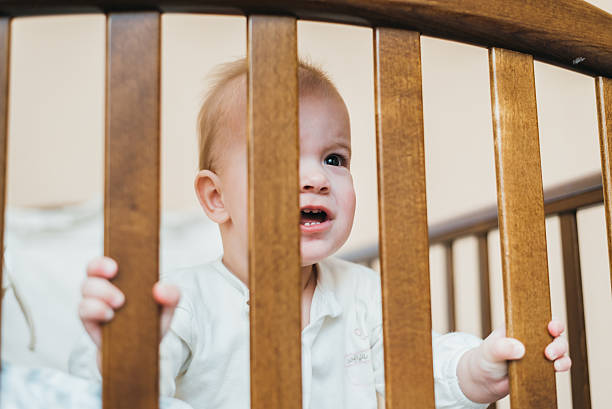 istock child looking through the bars of his bed 635740150