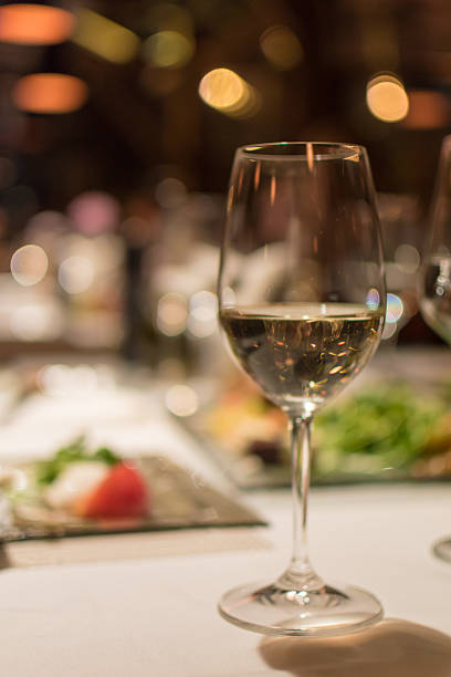 istock Glass of white wine on a restaurant table 635741090