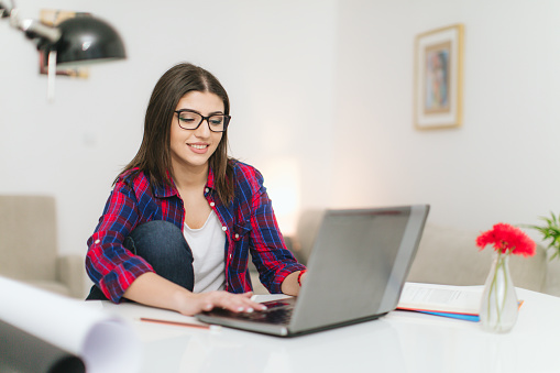 Young woman studying in livingroom