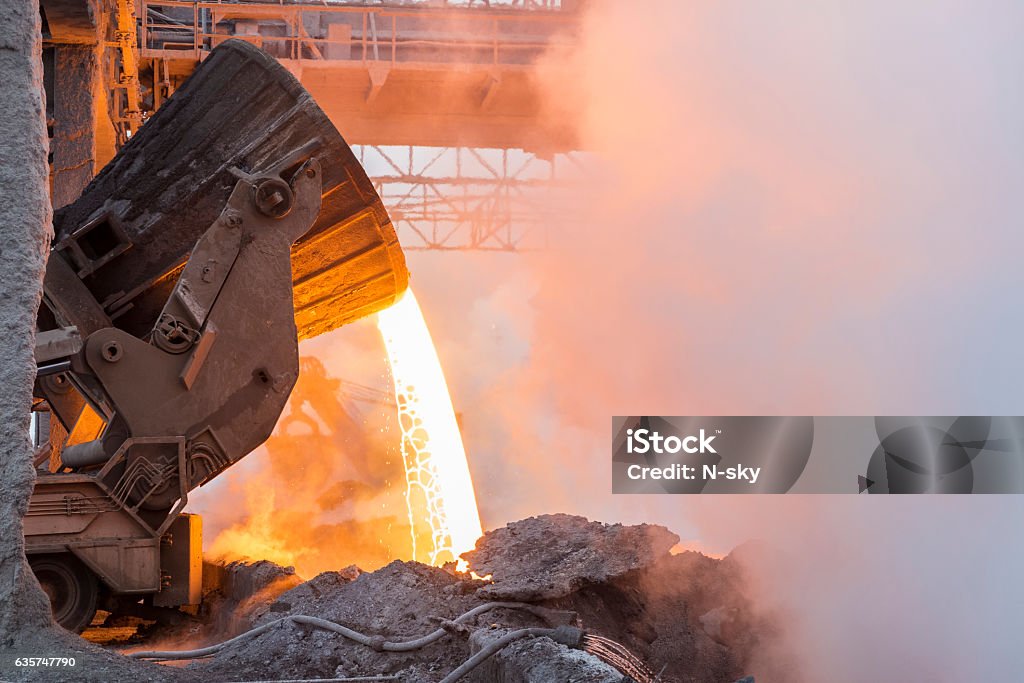 Metallurgy Heavy industry. Part of the process in metallurgy. Pouring the hot melt from the vat. Steel Mill Stock Photo