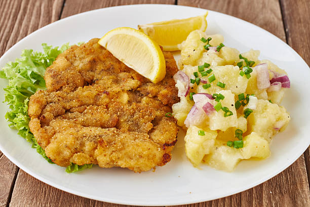 schnitzel de weiner con ensalada de patatas sobre un fondo de madera - viennese schnitzel fotografías e imágenes de stock