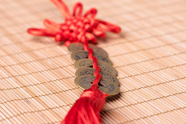 istock Decorative Chinese lucky coins with knot on bamboo mat 635755838