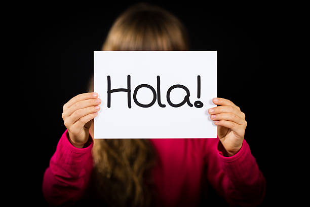 istock Child holding sign with Spanish word Hola - Hello 635755886