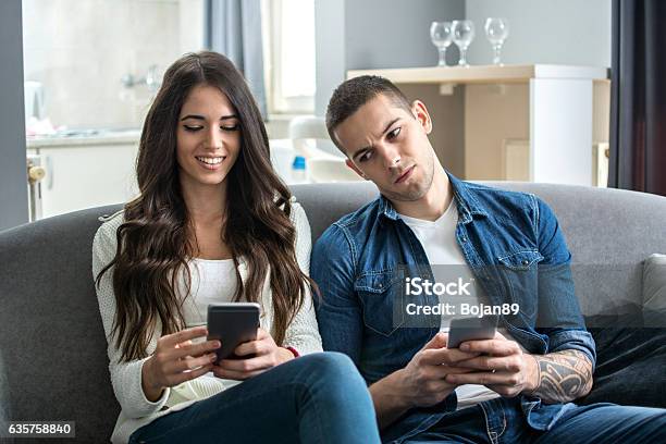 Jealous Boyfriend Spying His Girlfriends Phone Stock Photo - Download Image Now - Envy, Couple - Relationship, Men