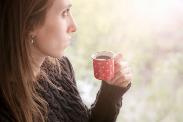 istock Young woman dreaming with cup of coffee 635766644