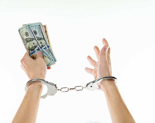 istock Businessman hands in handcuffs holding US dollars 635767086