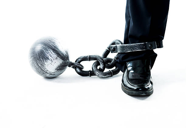 istock Businessman standing with ball and chain 635767570