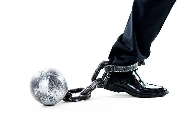 istock Businessman walking with ball and chain 635767720