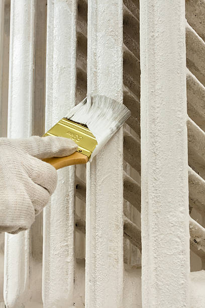 istock hand painting radiator central heating with brush 635772450