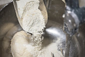 Loading flour into an industrial dough mixer.