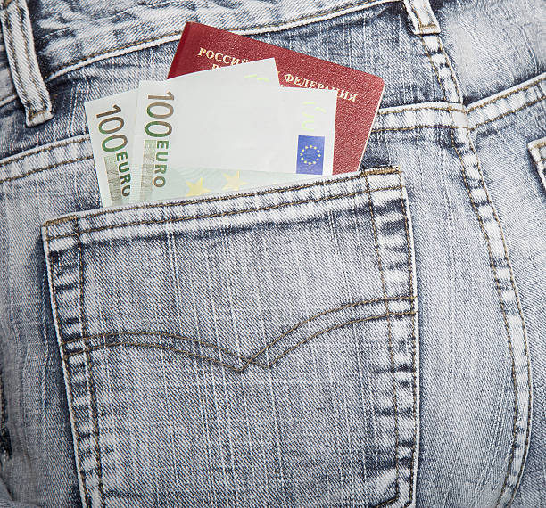 Slice of a cover of the Russian passport and notes The Russian passport and two notes on hundred euros in a hip-pocket of jeans jeans denim passport pocket stock pictures, royalty-free photos & images