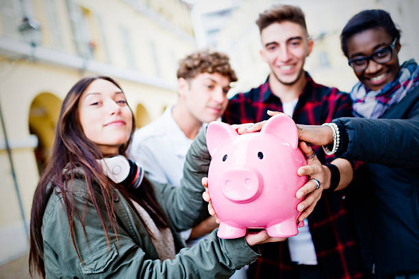 Group of mixed race people holding Piggy Bank stock photo